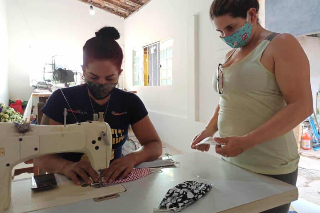 Inaleia Ferreira, campeão mundial de Muay Thai, produzindo máscaras caseia com ajuda da vizinha Mariem Barbosa